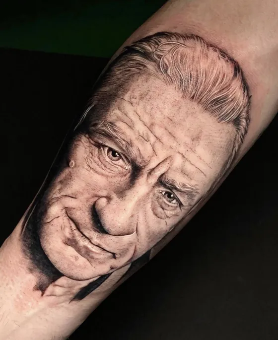 Realistisches Porträt eines älteren Mannes mit kantigem Gesicht als Unterarmtattoo
