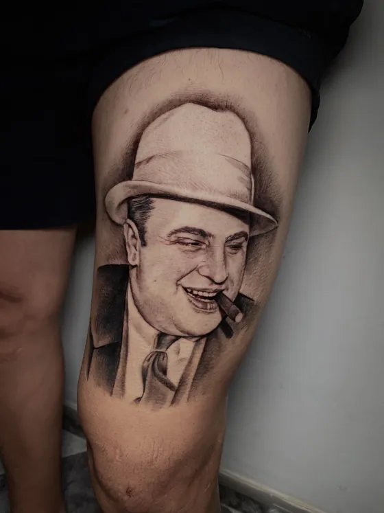 Porträt von Al Capone mit Hut und Zigarre als Oberschenkeltattoo