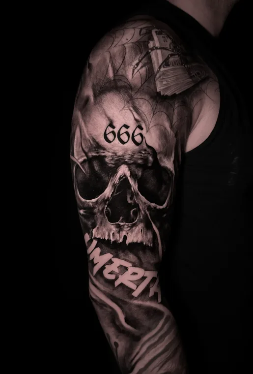 Detailliertes Totenkopfmotiv als dunkles Tattoo am Arm